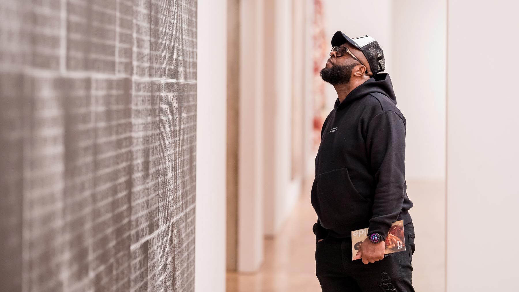 Man looking at a wall of art