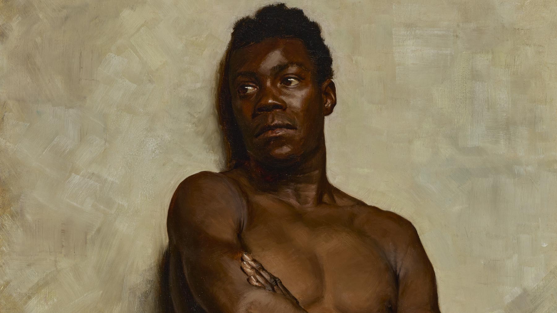 Black man with no shirt leaning against the wall with red and gold pants