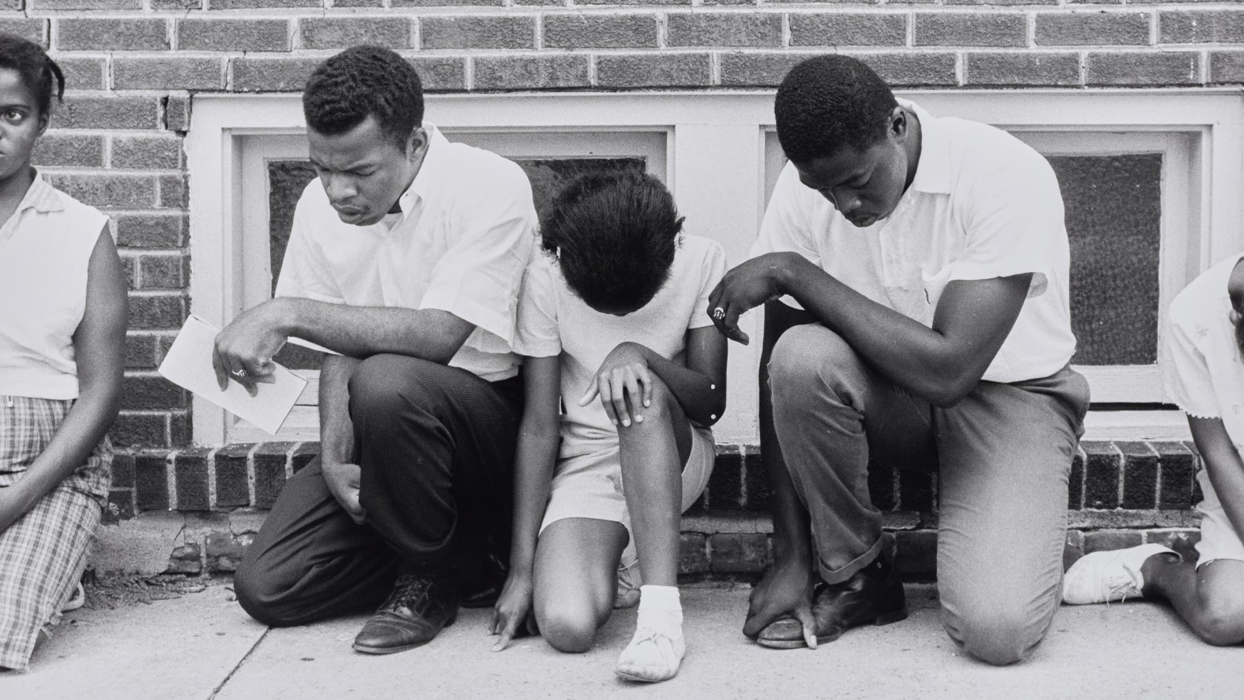 Danny Lyon, Cairo, Illinois. SNCC field secretary, later SNCC Chairman, now Congressman John Lewis, and others pray during a demonstration