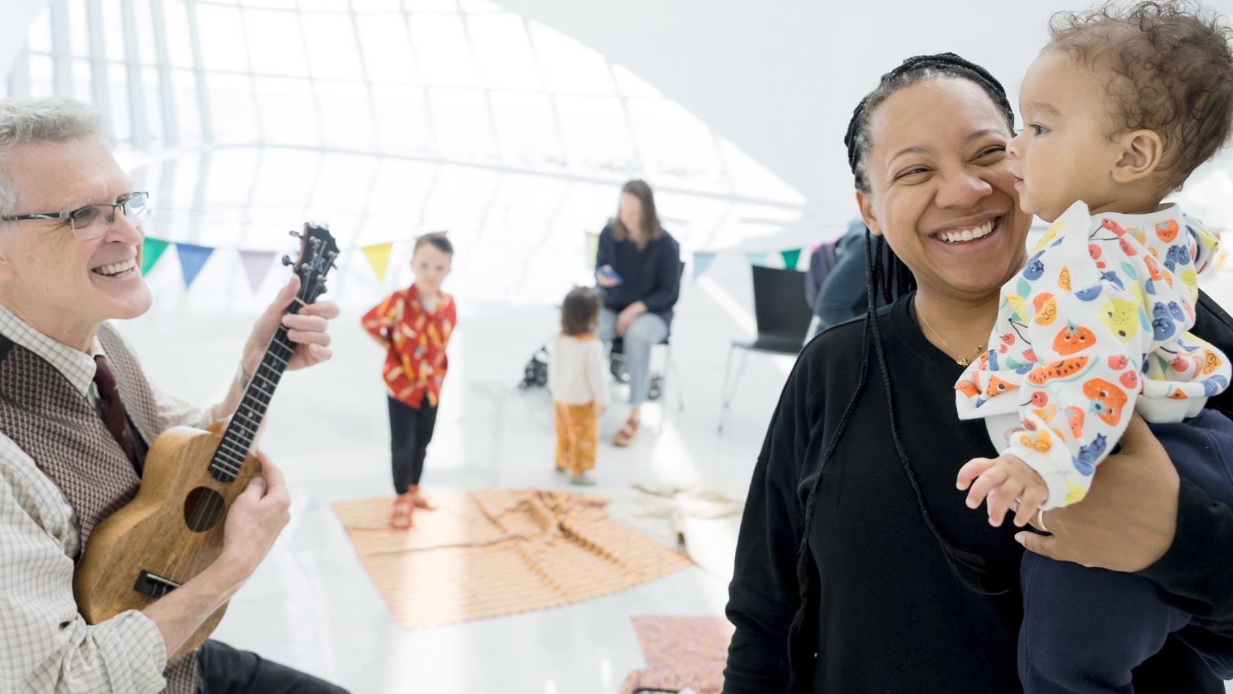 Mother holds her child while talking to a musical performer