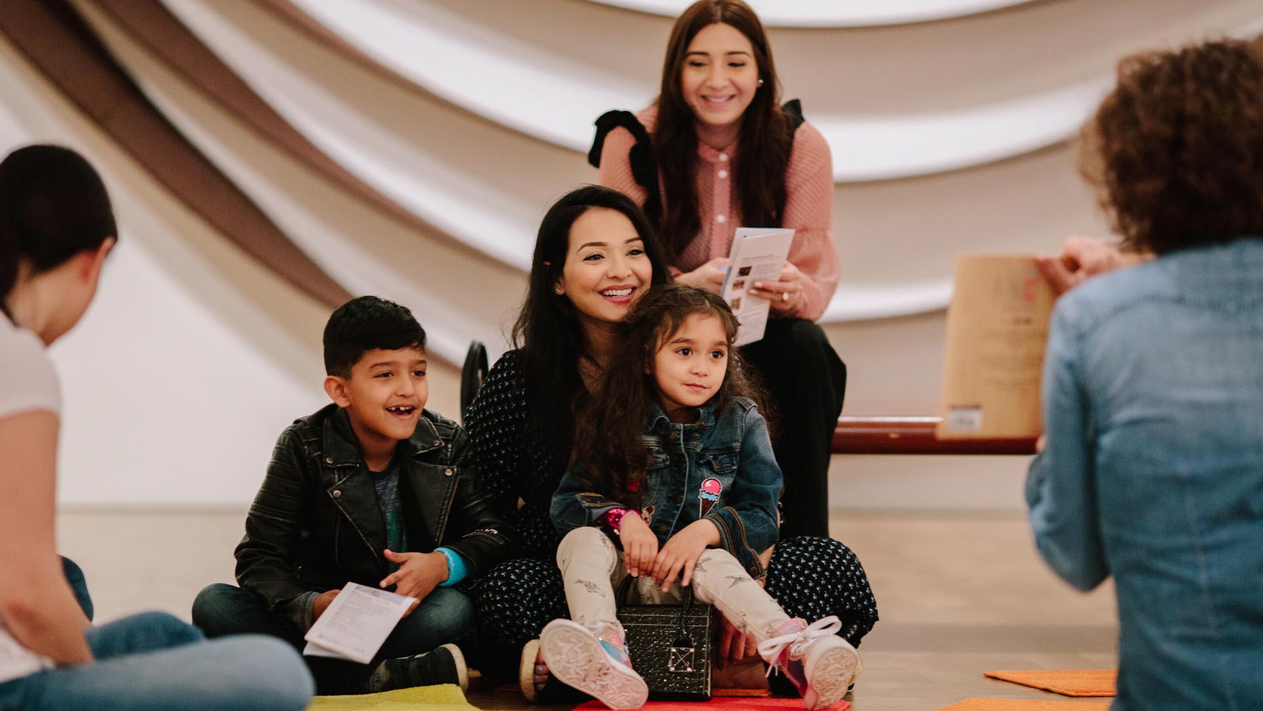 Emily reading a story to a family with small children