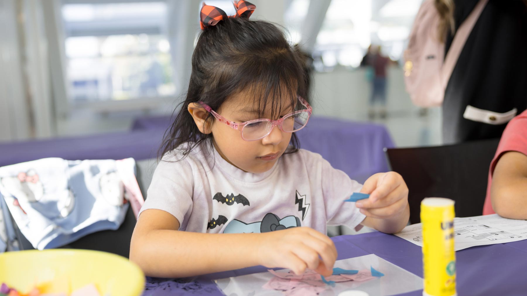Young girl making art with small pieces of paper