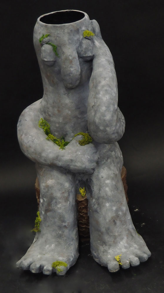 Ceramic vase of a troll sitting on a stump with algae in different places