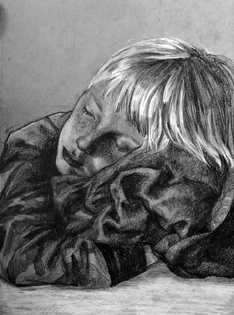 Young boy sleeping and hugging a blanket