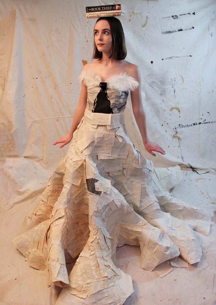 Sleeveless full-length dress made of book pages with feathers at the neckline