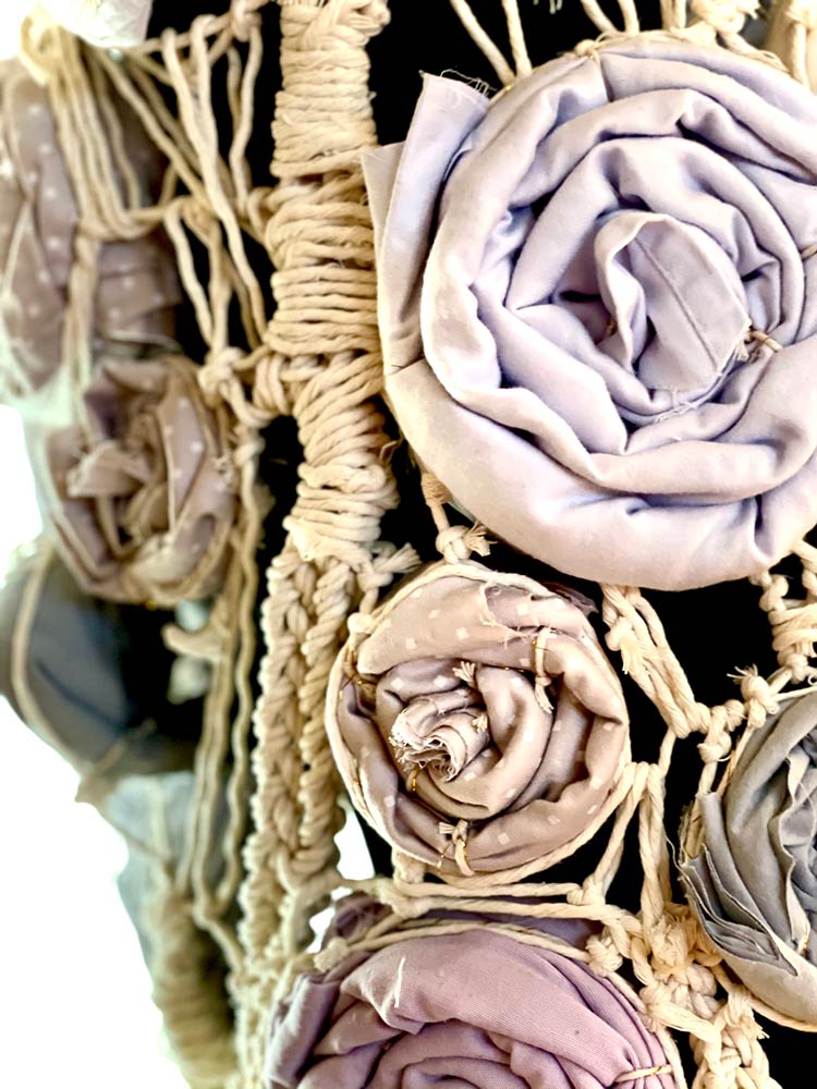 Close up of a top made of twisted and braided rope and cloth roses