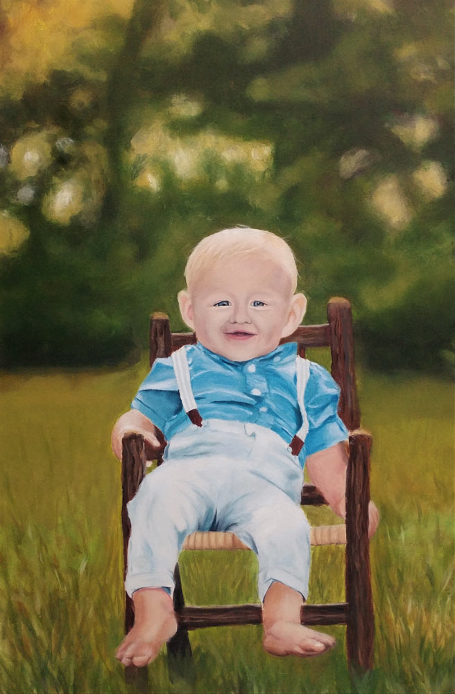 Toddler boy sitting in a wooden chair outside wearing suspenders