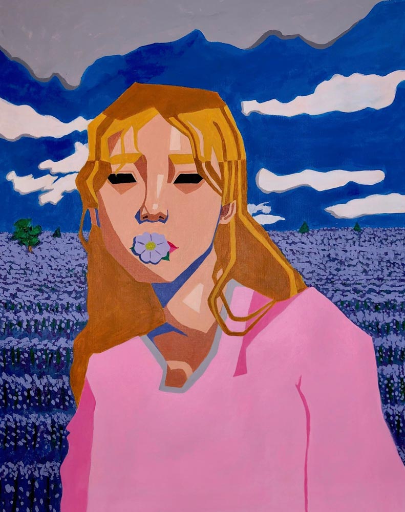 Teen girl in a pink shirt with a flower in her mouth standing in a field with a cloudy blue sky