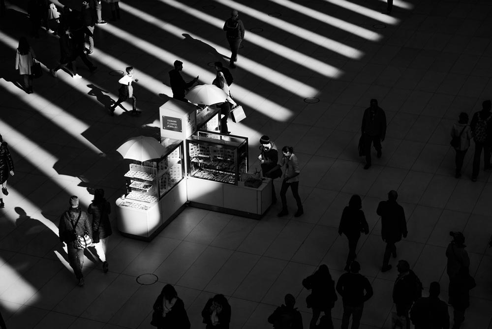 Looking down a a kiosk at a mall with people walking around