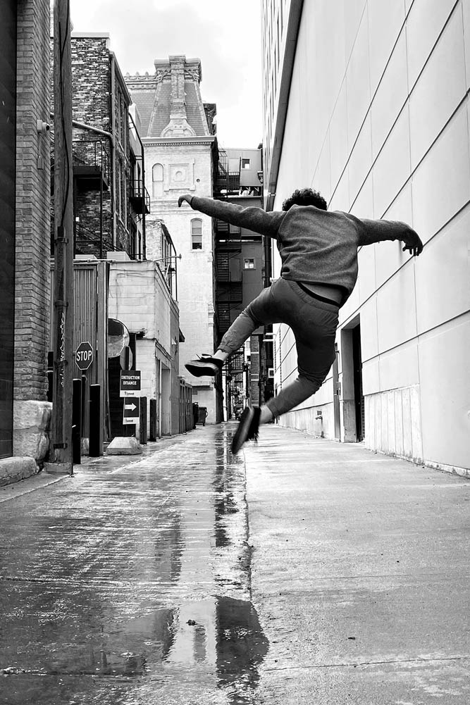 Young man from behind mid-jump in a alley