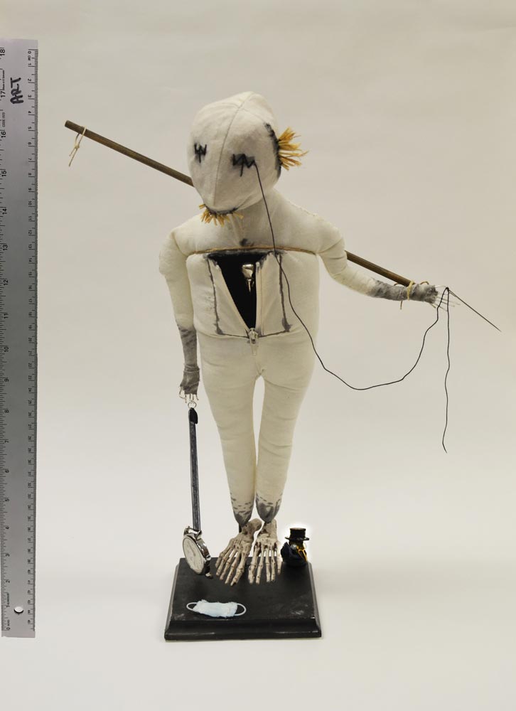 White stuffed doll dragging a clock in one hand and holding a stick in the other behind its back