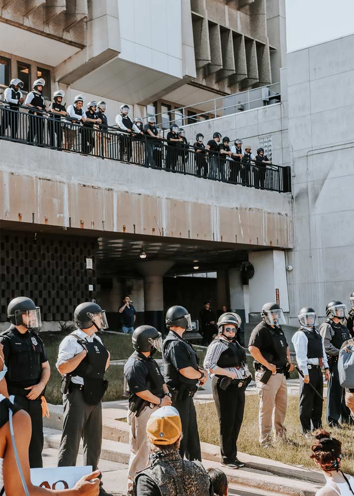 Wall of police officers in helmets and bulletproof jackets in front of a building