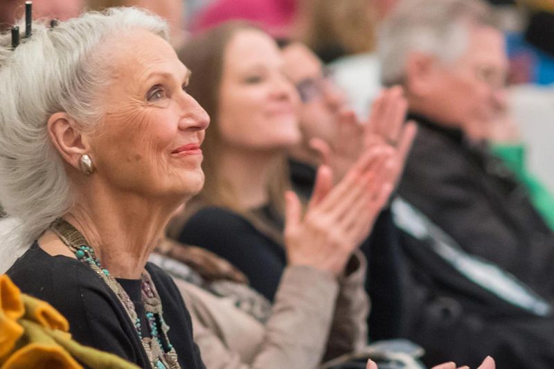 Older woman smiling during an event in Lubar Auditorium