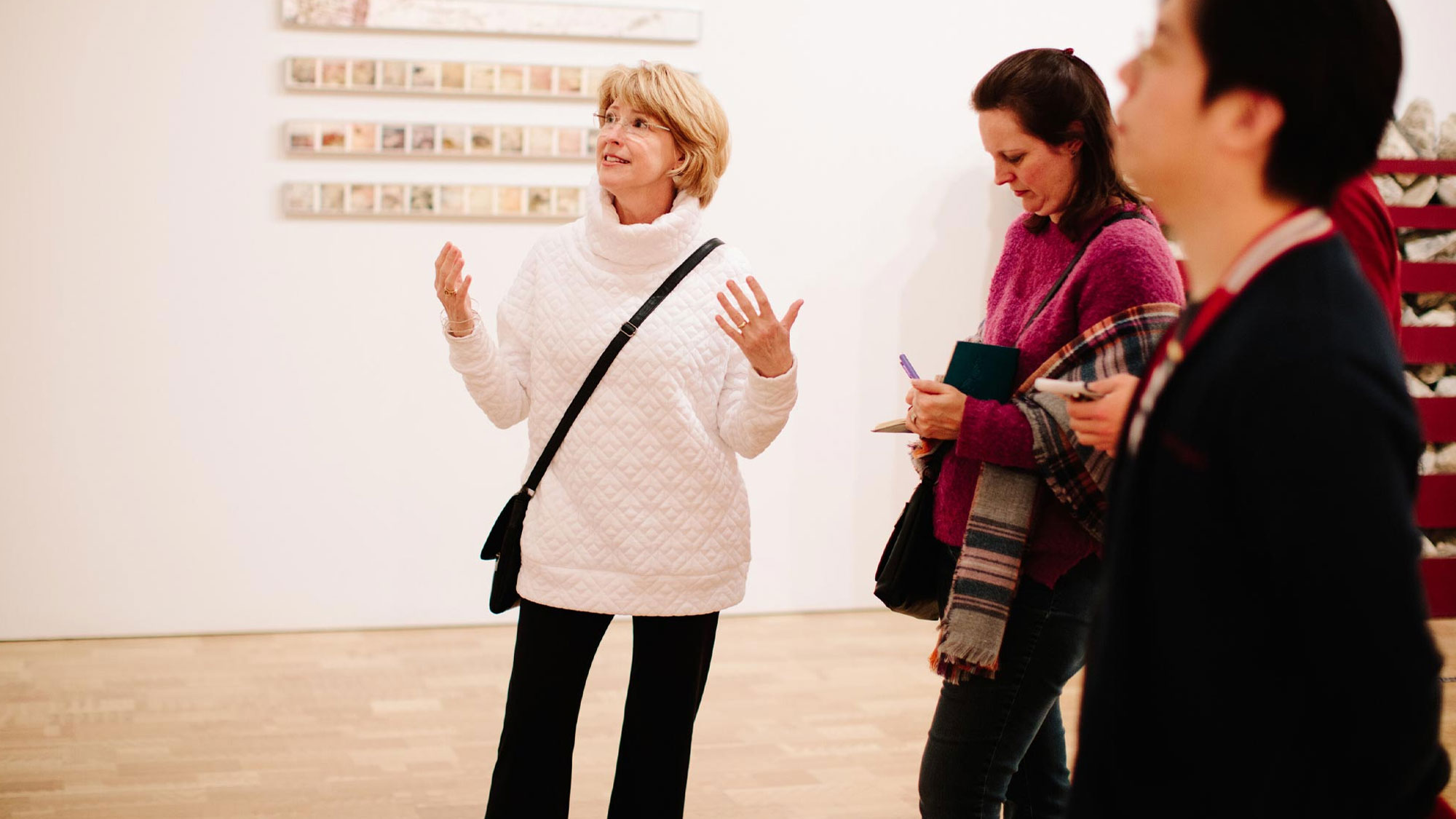 Woman talking about a work of art in front of a small group