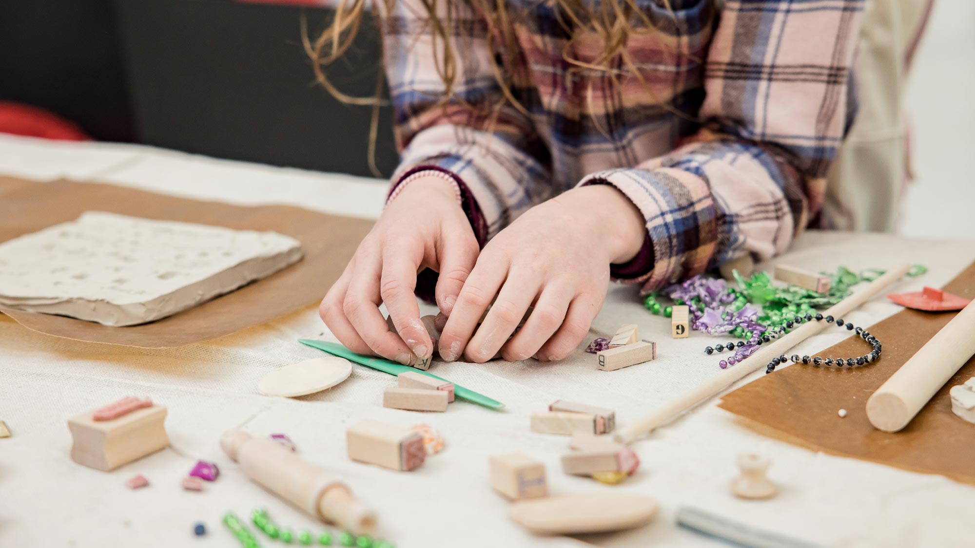 Young girl creating small sculptures with clay