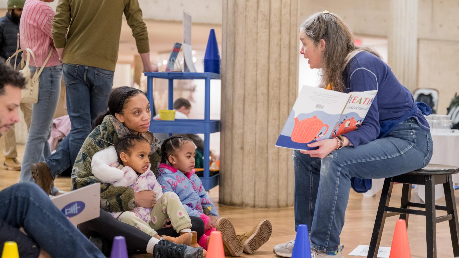 Woman reading a book to a group of children