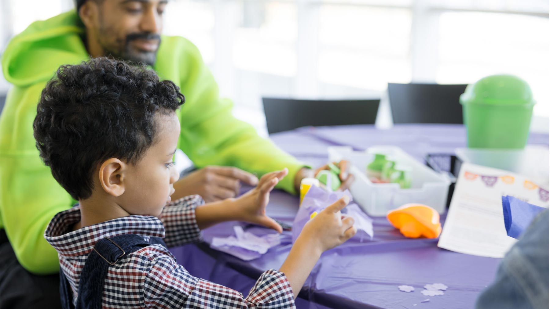 Young child creating art with his father