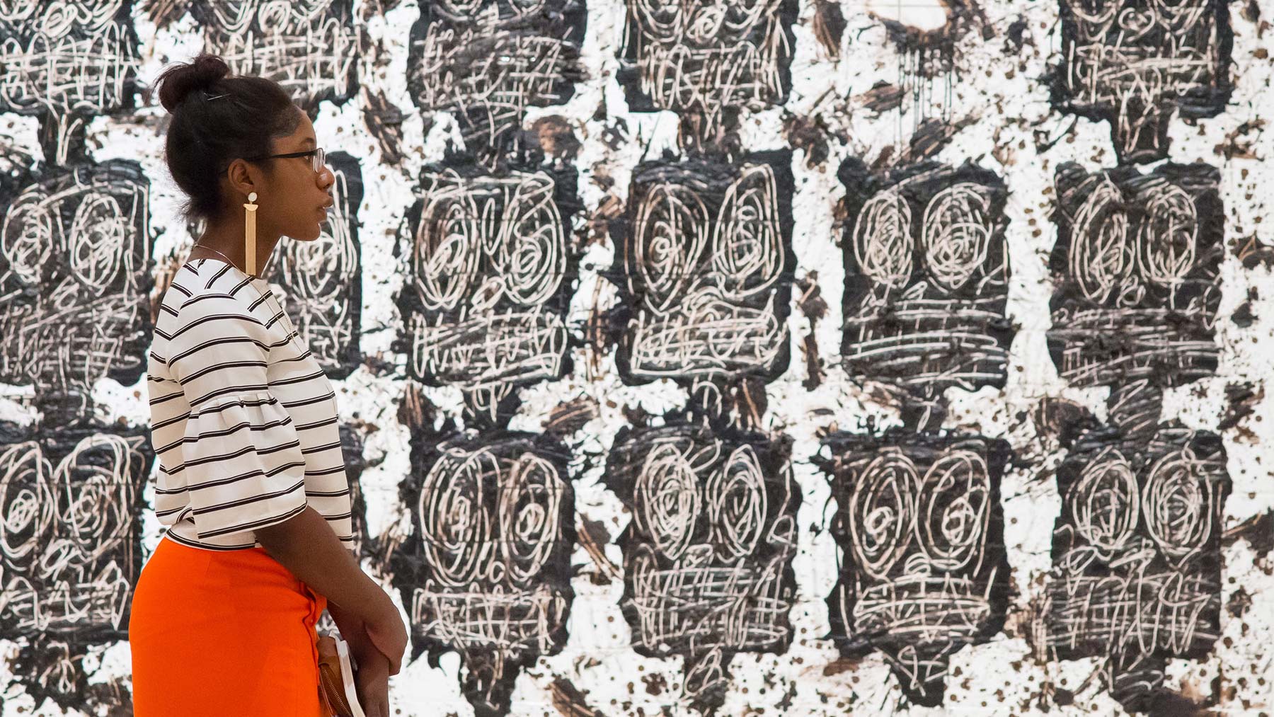 Woman walking in front of Untitled Anxious Audience