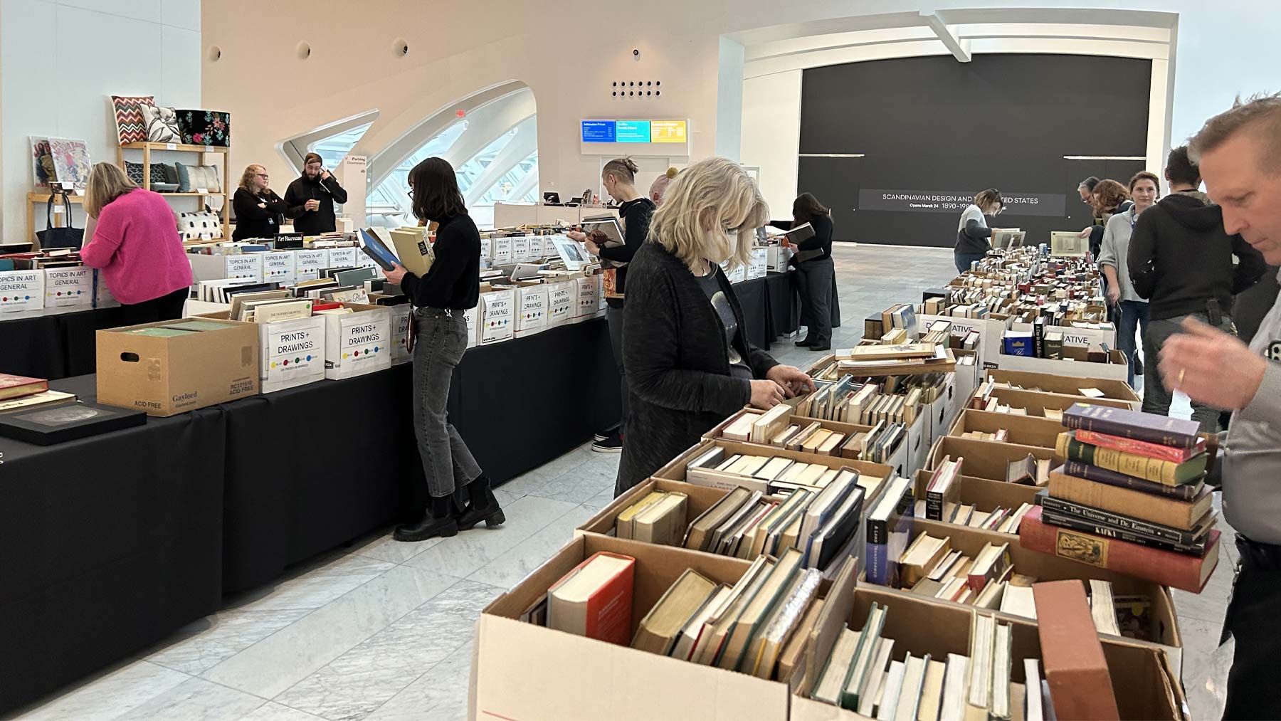 People browsing through boxes full of books at the Museum Store