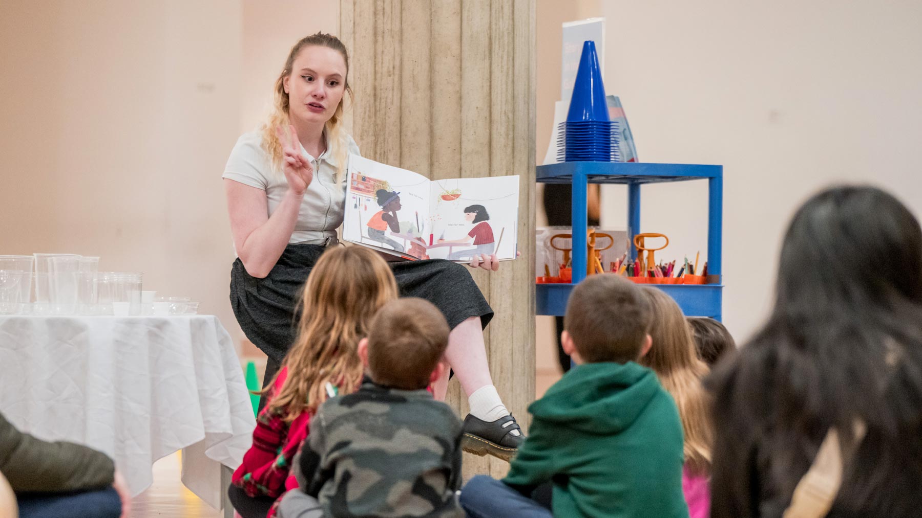 Woman reading a book to a group of children