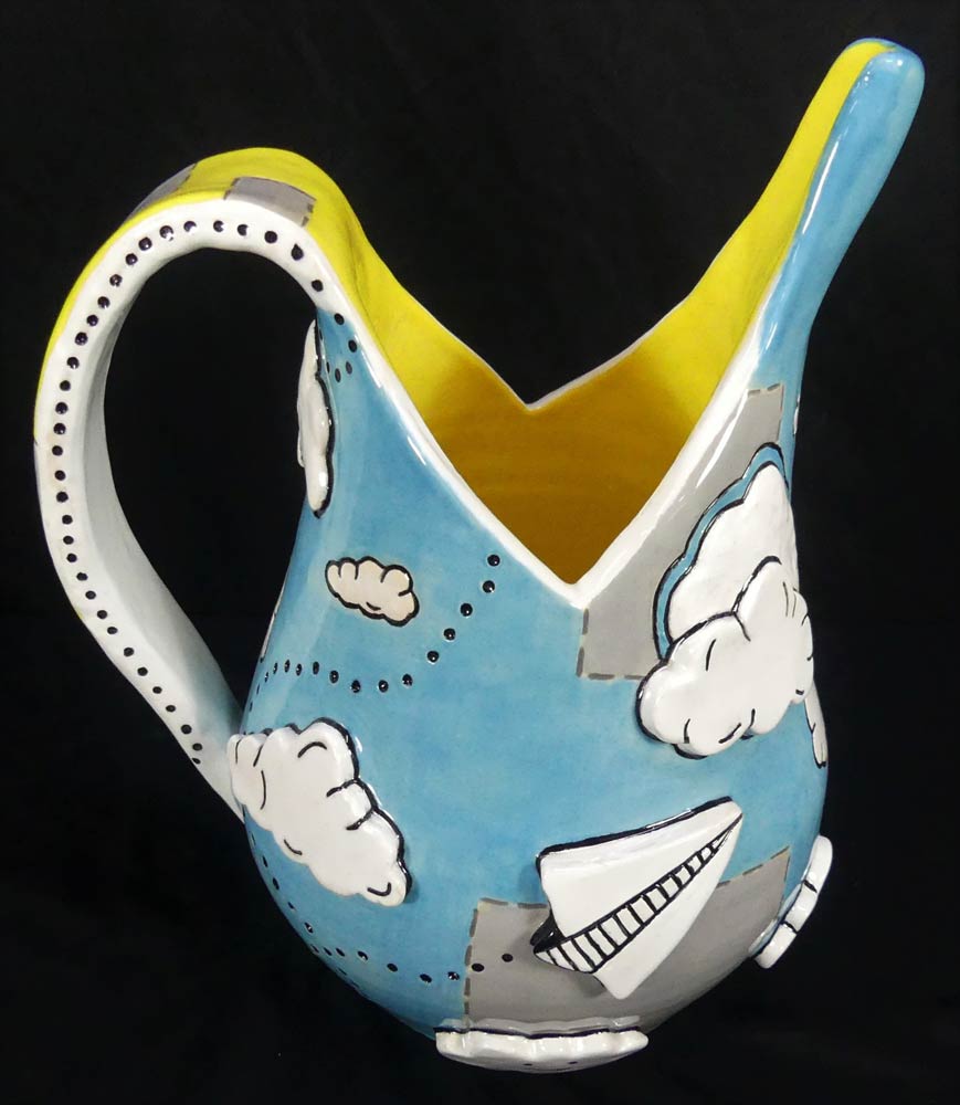 Ceramic vase designed in sky blue with clouds, paper airplanes, and dotted paths and a bright yellow interior