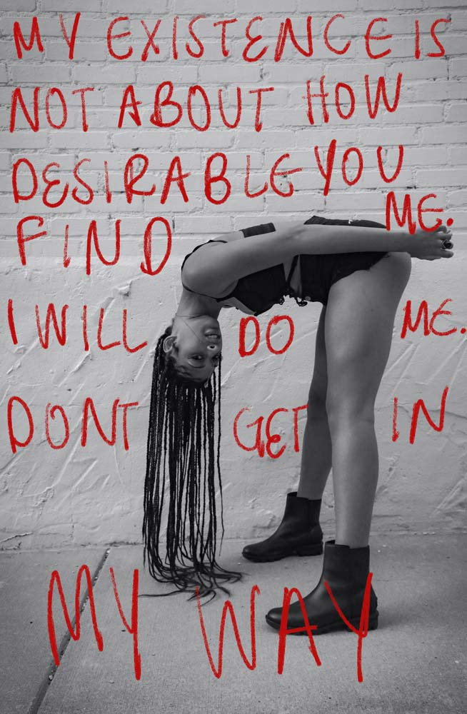 Photograph of a woman bending over and looking at the camera from her left side and her hair hanging to the floor, with the words 'My existence is not about how desirable you find me, I will do me, Don't get in my way' in the background