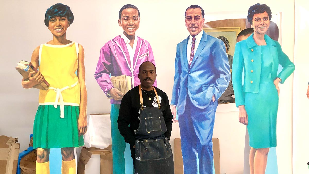 Man standing next to three different cardboard cutouts of people